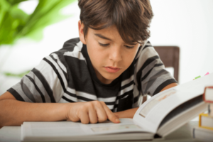 Jonge jongen aan het lezen